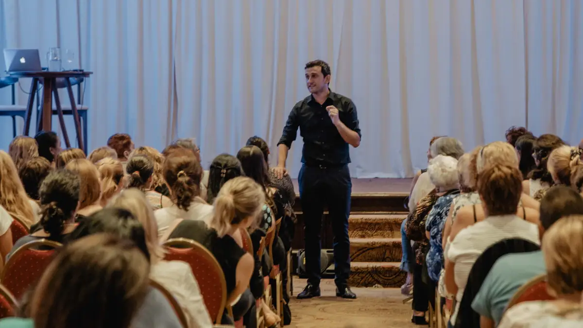 Federico Barolin hablando con el público de pie en el pasillo de un auditorio