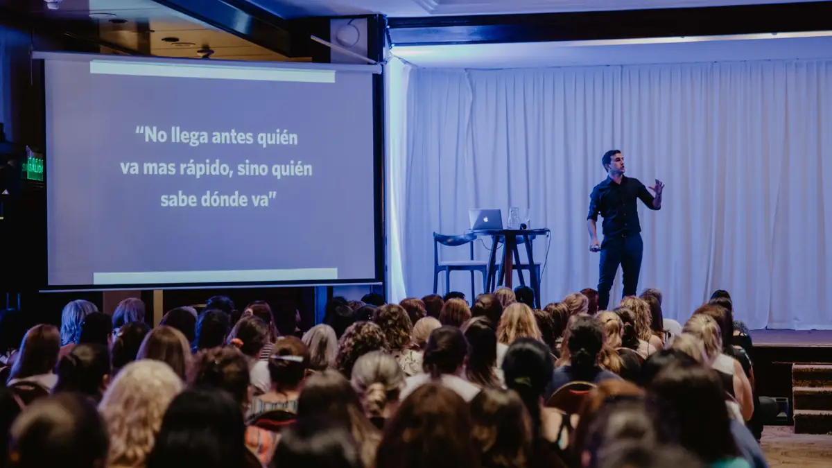 Federico Barolin en el escenario junto a una pantalla, frente al público